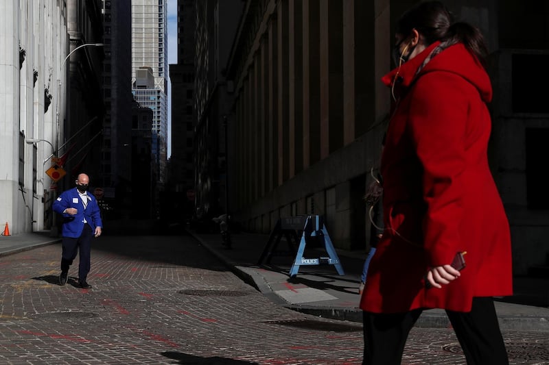 A trader wearing a protective face mask walks outside the New York Stock Exchange in the financial district of New York. Reuters