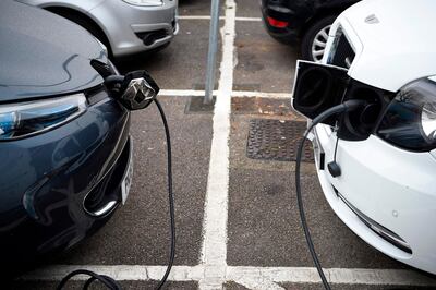 Electric vehicles (EV) charge at a charging station on east London on November 18, 2020. Britain will ban petrol and diesel vehicle sales from 2030 as part of a 10-point plan for a "green industrial revolution" to be unveiled Wednesday by Prime Minister Boris Johnson.  / AFP / DANIEL LEAL-OLIVAS
