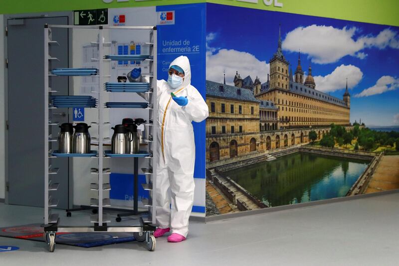 A health worker works beside a meal cart at Enfermera Isabel Zendal hospital in Madrid. Reuters