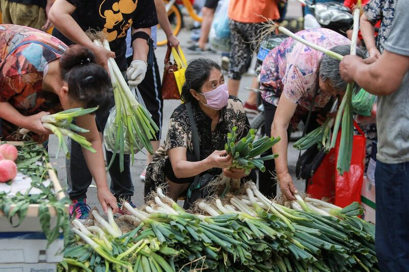 Customers buy vegetables at a market in Shenyang, in China's northeastern Liaoning province. AFP