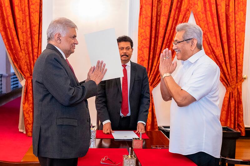 Sri Lanka's President Gotabaya Rajapaksa, right, greets Prime Minister Ranil Wickremesinghe in Colombo on Wednesday during his oath-taking ceremony as the new finance minister. AP