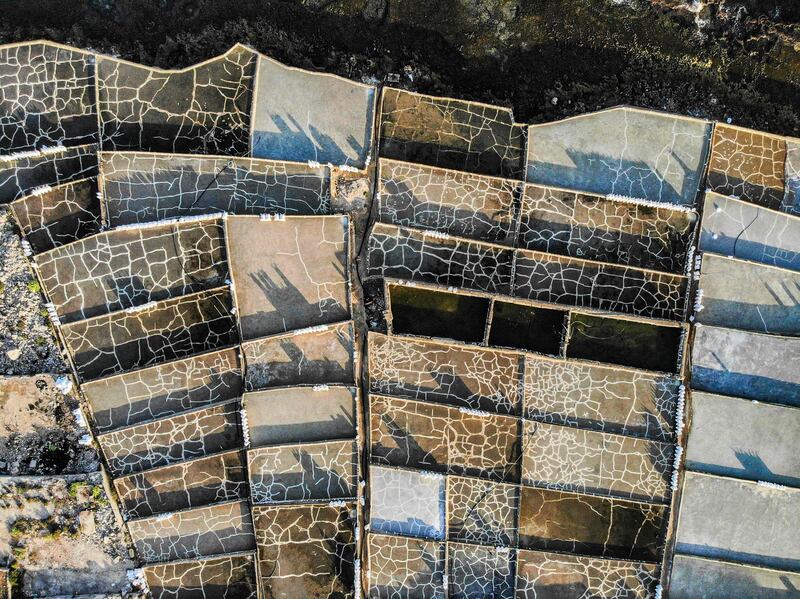 An aerial view of dried-up ponds near the Greek Orthodox Monastery of Our Lady of Al Natour, unseen, along the Mediterranean sea coast near Lebanon's northern city of Anfeh, which were previously used in the traditional production of salt by seawater evaporation.  AFP