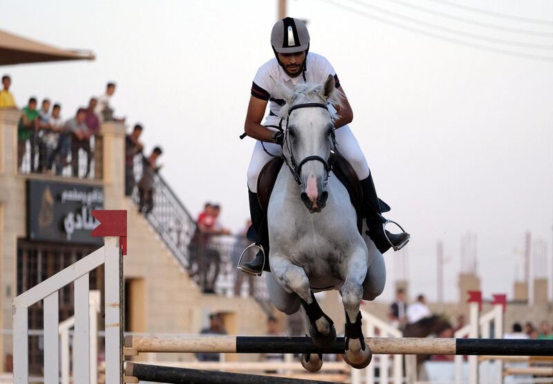 A rider on his horse jumps over a barrier during the Knights of Libya Festival in Benghazi, Libya. Reuters
