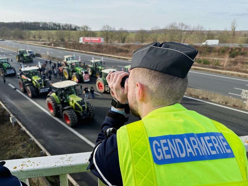 A French gendarme watches on from a bridge as farmers block a motorway in Longvilliers, near Paris. Reuters