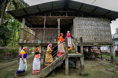 Deori tribal women move to a traditional Deori hut after casting their vote during the first round of polling of India's national election in Jorhat, India. AP