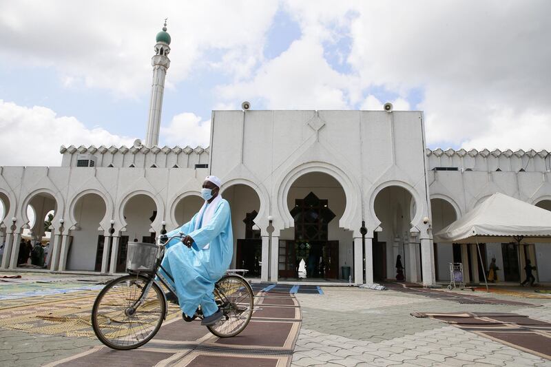 An Ivorian Muslim arrives by bike in front of a mosque during the Eid al-Fitr Muslim celebration marking the end of the fasting month of Ramadan, in Abidjan, Ivory Coast. EPA