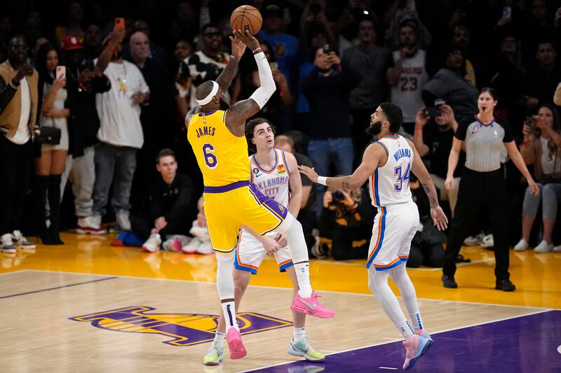 Los Angeles Lakers forward LeBron James, left, scores to become the NBA's all-time leading scorer. AP