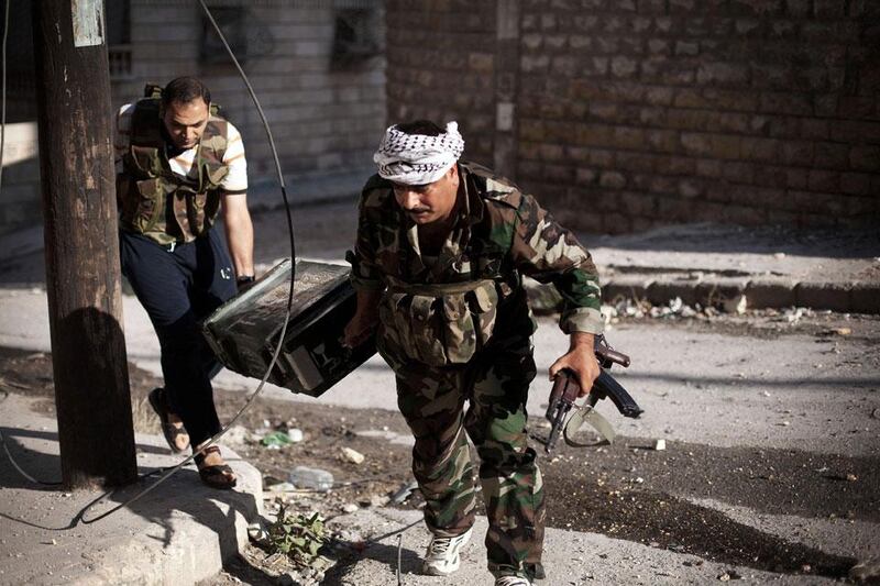 Two rebel FSA soldiers carry munitions to the front line during fighting in the Izaa district.  Manu Brabo / AP Photo