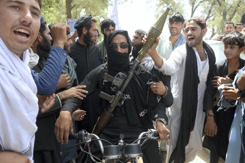 An Afghan Taliban militant carries a rocket-propelled grenade as he looks on with residents as they celebrate a ceasefire on the second day of Eid on the outskirts of Jalalabad on June 16, 2018.
Taliban fighters and Afghan security forces hugged and took selfies with each other in restive eastern Afghanistan on June 16, as an unprecedented ceasefire in the war-torn country held for the second day of Eid. / AFP PHOTO / NOORULLAH SHIRZADA