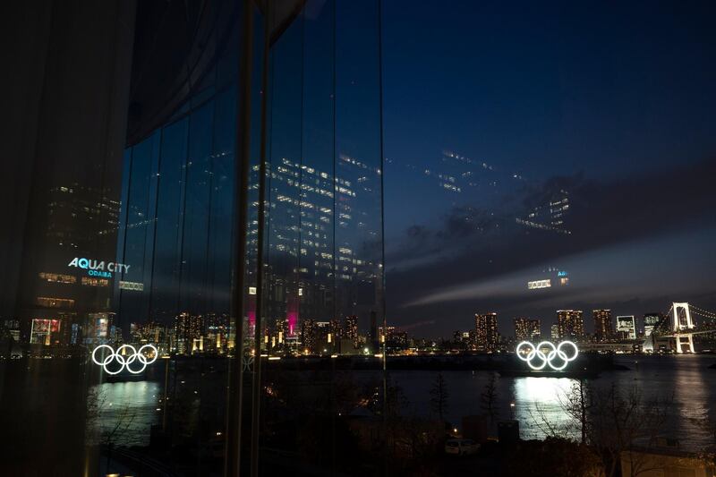 The Olympic rings are reflected in the glass wall of a wedding chapel in the Odaiba section of Tokyo. AP