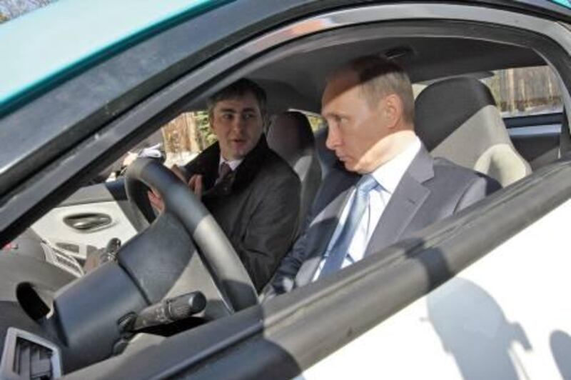 epa02664247 Russian Prime Minister Vladimir Putin (R) sits at the wheel of the new Yo-Mobile car while listening to explanations of Yarovit  (name of producer) director general Andrei Biryukov outside Moscow, Russia, 01 April 2011. Yo-mobile is a new Russian car platform with a hybrid engine, promoted by Russian businessman Mikhail Prokhorov.  EPA/ALEXEY NIKOLSKY/POOL MANDATORY CREDIT: RIA NOVOSTI /*** NO SALES NO ARCHIVES NOT FOR USE AFTER 01 MAY 2011*** *** Local Caption ***  02664247.jpg