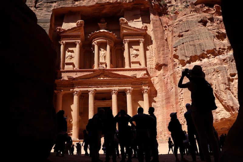 Tourists take pictures of the Khazneh (Treasury) in Jordan's ancient city of Petra on May 5, 2017. 
Established as the capital city of the Nabataeans, the rose rock city is Jordan's most popular touristic site and was chosen as one of the seven New Wonders of the World in 2007. / AFP PHOTO / THOMAS COEX