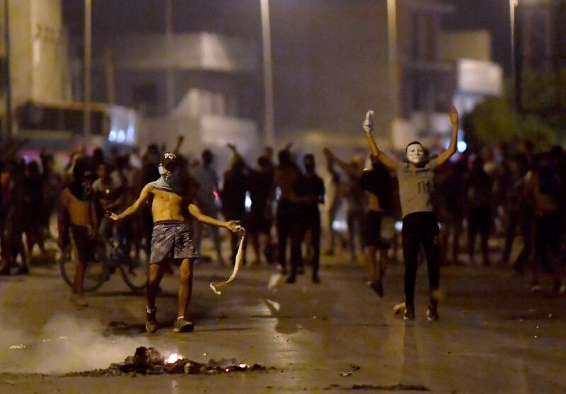 Protesters gesture as they block a street in the Sidi Hassine suburb on the north-west outskirts of Tunis. AFP