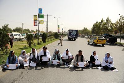 epa06947731 Two Afghan civil society women along with six other men wear gravecloths, hold placards written in farsi 'Rescue Ghazni Province' and block a busy road to pressure government for securing Ghazni province, in downtown Kabul, Afghanistan, 13 August 2018. The combat for the strategic city of Ghazni province has entered its fourth day, according to officials at least 135 people most of them police officers have been killed and 170 others are injured. Afghan special forces with US air force support have started a large operation to eliminate Taliban insurgents and take back the control of the city.  EPA/JAWAD JALALI