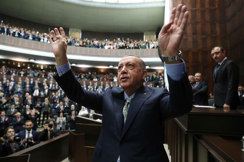 Turkey's President Recep Tayyip Erdogan waves to members of his ruling Justice and Development Party (AKP), after addressing them at the parliament in Ankara, Turkey, Tuesday, Oct. 23, 2018. Saudi officials murdered Saudi writer Jamal Khashoggi in their Istanbul consulate after plotting his death for days, Erdogan said, contradicting Saudi Arabia's explanation that the writer was accidentally killed. He demanded that the kingdom reveal the identities of all involved, regardless of rank (Presidential Press Service via AP, Pool)