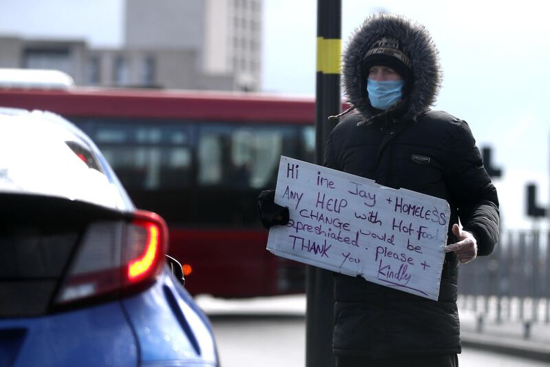  A homeless man wearing a protective face mask appeals for help to passing motorists as the spread of the coronavirus disease (COVID-19) continues, Birmingham, Britain, March 30, 2020. REUTERS/Carl Recine