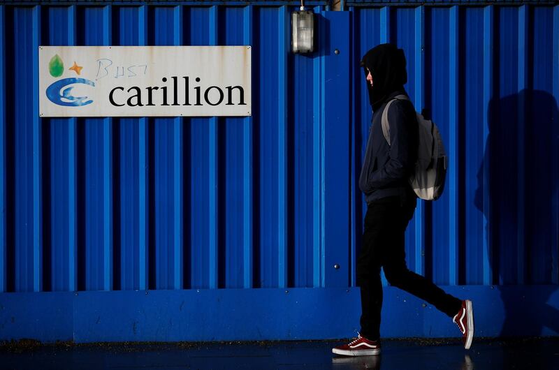 A person walks past defaced branding outside Carillion's Royal Liverpool Hospital site in Liverpool, Britain, January 16, 2018. REUTERS/Phil Noble