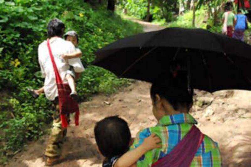 Karen families walk to church. Despite living in a refugee camp in Thailand, members of this Myanmar hilltribe are reluctant to leave the camp and move away from their homeland, which has made resettlement programs hard. Jesse Wright/The National