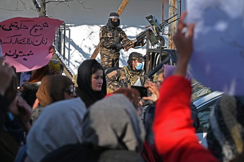 Taliban fighters stand guard as Afghan women protest at Shahr-e Naw in Kabul on December 16, 2021. AFP