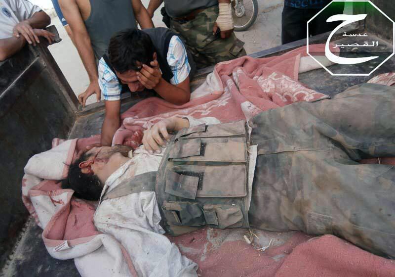 This citizen journalism image provided by Qusair Lens which has been authenticated based on its contents and other AP reporting, shows Fadi Kerkoz mourning next to a body of his brother Shadi Kerkoz, who was killed in a battle against Syrian forces loyal to Syrian President Bashar Assad, in the town of Qusair, near the Lebanon border, Homs province, Syria, Sunday, June 2, 2013. Syrian rebels fought with gunmen from the Hezbollah militia in a deadly clash on Lebanese soil, a security official and local media said Sunday, in the latest sign Syria's civil war is spilling over the country's borders. (AP Photo/Qusair Lens) *** Local Caption ***  Mideast Syria.JPEG-08ec3.jpg