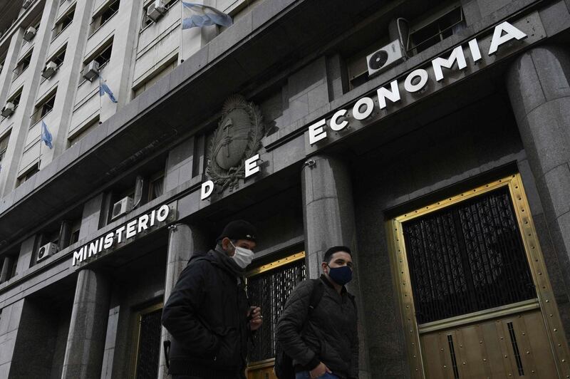 (FILES) In this file photo taken on May 22, 2020 Men walk past Argentina's Economy Ministry building during the lockdown imposed by the government against the spread of the new coronavirus, in Buenos Aires.  Three groups of creditors announced on July 20, 2020 they had rejected Argentina's proposal to restructure $66 billion of debt and have made a counter offer to President Alberto Fernandez's government. "Argentina's offer is short of what the creditor groups can accept," said the creditors in a statement, adding that they would not meet the government's August 4 deadline to find an agreement. / AFP / JUAN MABROMATA
