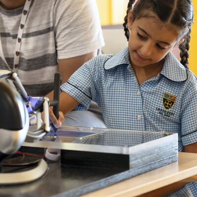 A Cranleigh pupil uses a robot to steady her hand during a new trial. Courtesy: Cranleigh