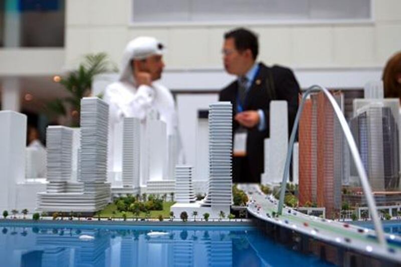 ABU DHABI - UNITED ARAB EMIRATES - 17APRIL2013 - Visitors look at a model of Al Maryah Island project by Mubadala on the second day at Cityscape Abu Dhabi 2013 at Abu Dhabi National Exhibition Centre. Ravindranath K / The National