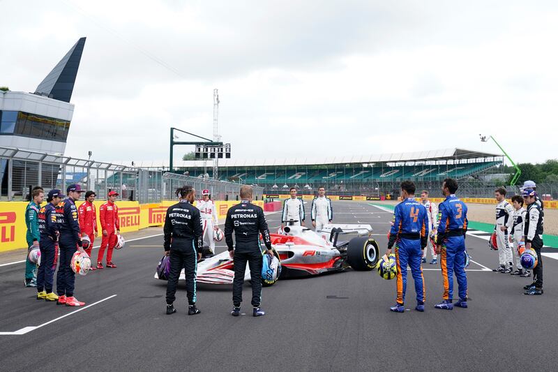 Drivers gather around a model of the 2022 F1 car.