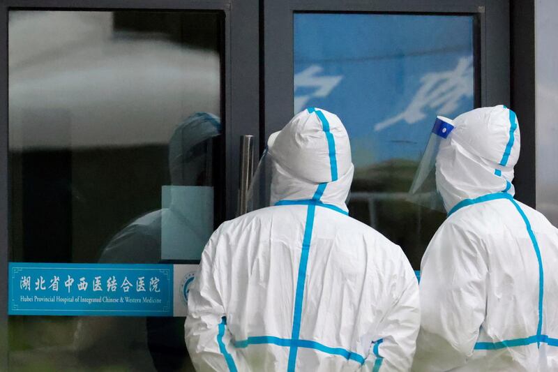 Staff members in protective suits stand at Hubei Provincial Hospital of Integrated Chinese and Western Medicine where members of the World Health Organisation (WHO) team tasked with investigating the origins of the coronavirus disease (COVID-19) are visiting, in Wuhan, Hubei province, China. Reuters