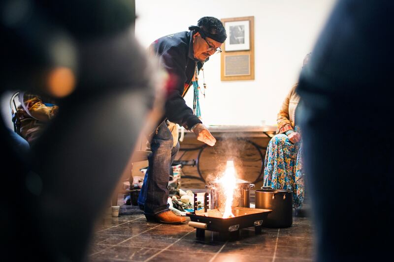 Medicine Man Herbert Wilson, a citizen of the Dine, or Navajo Nation, lights the ceremonial fire for the cleansing ceremony he led in Carpenter Hall at Dartmouth College. AP