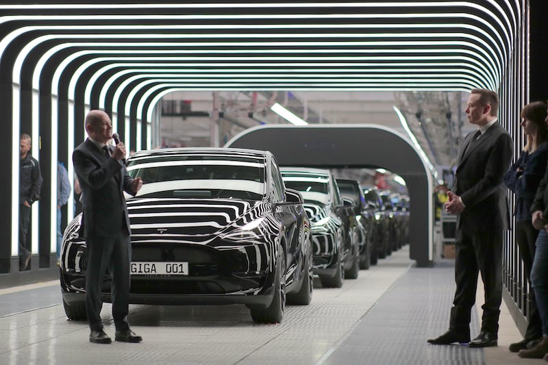 The Tesla chief, right, was cheered as he oversaw the handover of the car maker's first German-made cars at the Gruenheide plant.   EPA