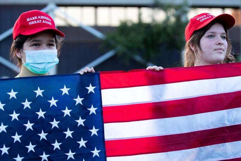 Supporters of President Donald Trump hold up a flag during a protest against the election results at the Maricopa County Elections Department office in Phoenix, Arizona. AFP