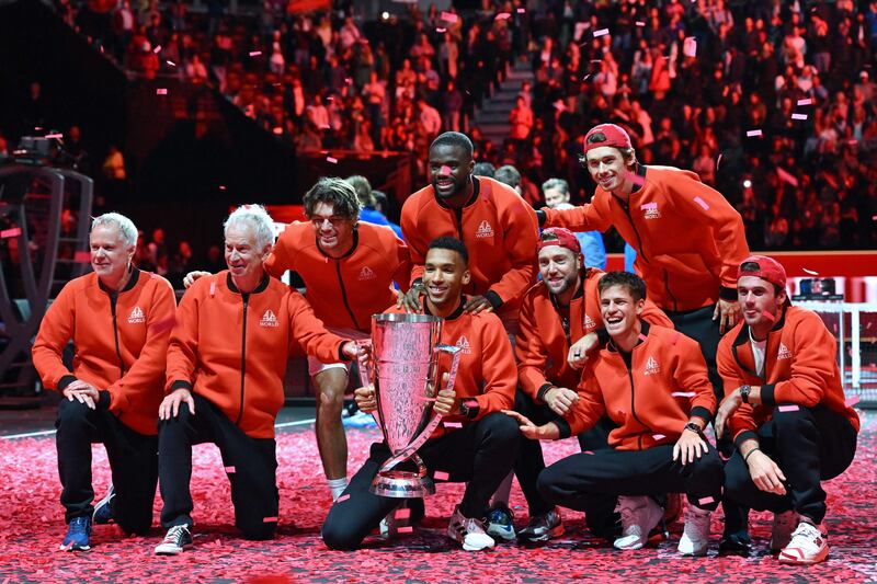 Team World (L-R) vice captain Patrick McEnroe, captain John McEnroe, USA's Taylor Fritz, Canada's Felix Auger-Aliassime, USA's Frances Tiafoe, USA's Jack Sock, Australia's Alex De Minaur, Argentina's Diego Schwartzman and USA's Tommy Paul pose with the trophy on the court after victory. AFP