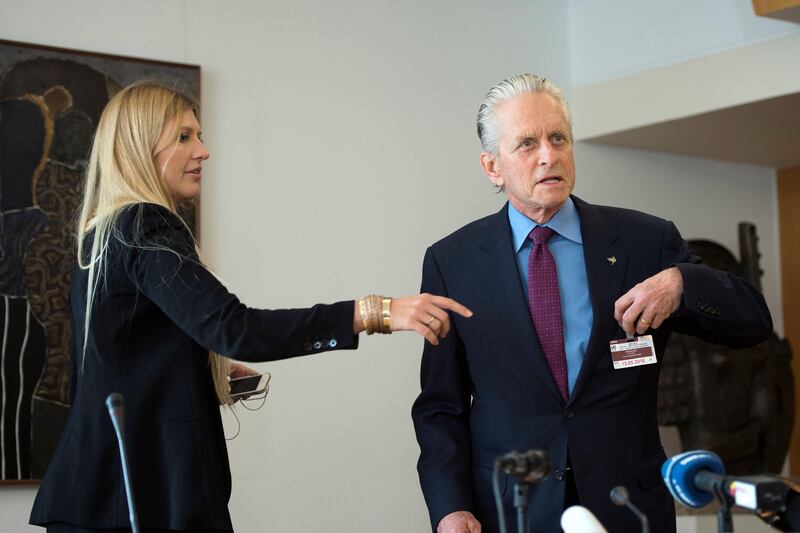 FILE - In this May 12, 2016 file photo Beatrice Fihn, left, Executive Director of the International campaign to abolish Nuclear Weapons (ICAN), and Actor and UN Messenger of Peace Michael Douglas, right, attend a meeting about the Nuclear Disarmament, at the European headquarters of the United Nations, in Geneva, Switzerland. (Martial Trezzini/Keystone via AP)