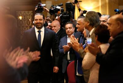 Journalists and supporters of Lebanese Prime Minister--designate Saad Hariri, left, clap as he arrives for a press conference, in Beirut, Lebanon, Tuesday, Nov. 13, 2018. Hariri accused Hezbollah of hindering the formation of a new government six months after parliamentary elections. He said the Shiite militant group bears full responsibility for the consequences, including Lebanon's flagging economy. (AP Photo/Hussein Malla)