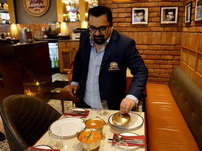 Chief executive Amit Bagga shows off dishes of butter chicken and dal makhani at an outlet of the Daryaganj restaurant chain in Noida, India. Reuters