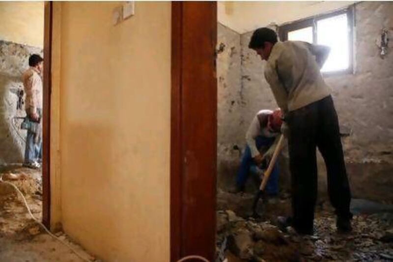 Workers demolish the inside of houses in Sharjah.