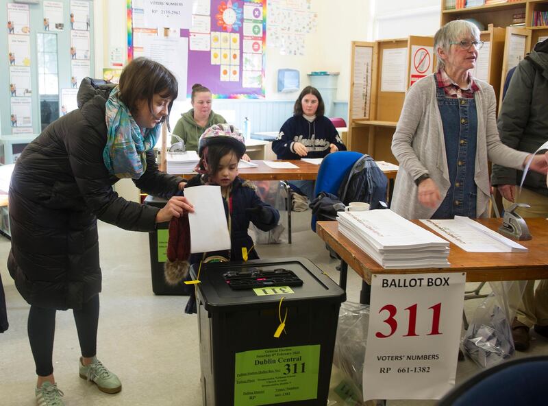 A woman helps her daughter to cast a vote at a polling station during general elections in Dublin, Ireland.  EPA