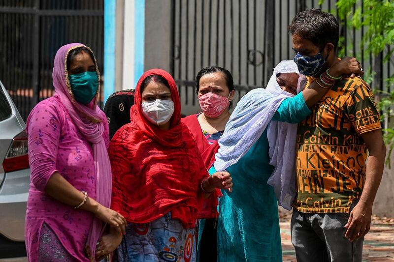 Relatives mourn as they wait to receive the body of their loved one, who died due to the Covid-19, at a mortuary in New Delhi. AFP