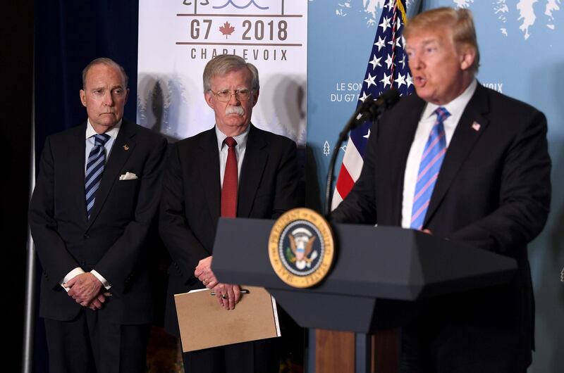 Director of the US National Economic Council National Larry Kudlow, left, and Security Adviser John Bolton listen as US President Donald Trump speaks to reporters at the G7 Summit in La Malbaie, Quebec. Saul Loeb / AFP