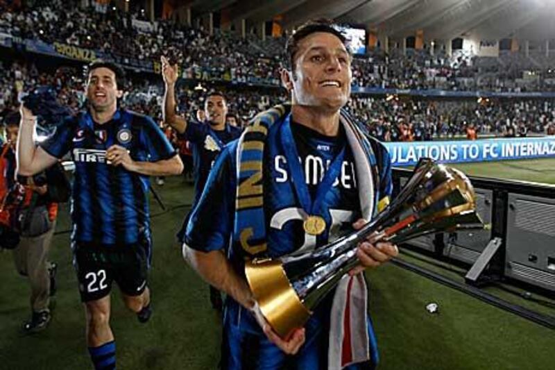 Javier Zanetti, the Inter Milan captain, holds the Club World Cup trophy as the players perform a lap of honour around Zayed Sports City.