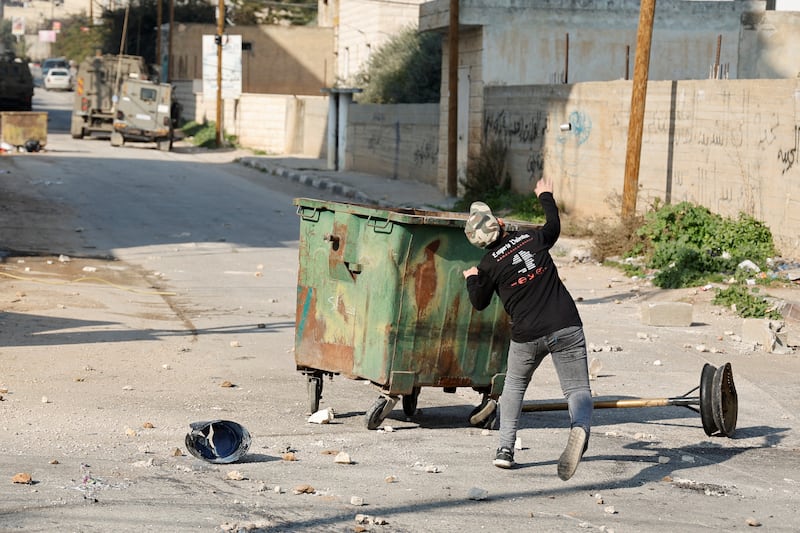 A Palestinian hurls a canister during the raid in the occupied West Bank. Reuters