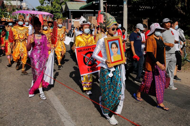 Protesters hold up an image of Aung San Suu Kyi and signs as they demonstrate against the military coup in Myeik, Tanintharyi region. AFP