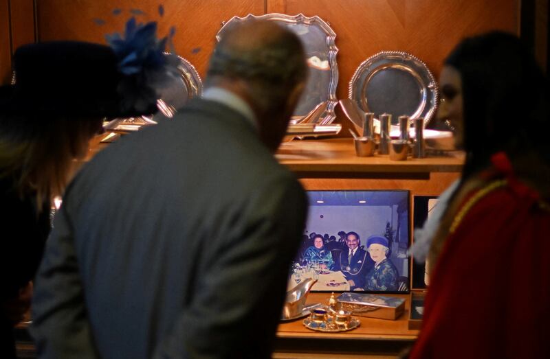 While at the town hall, the king is shown a photograph of his late mother, Queen Elizabeth II. Reuters