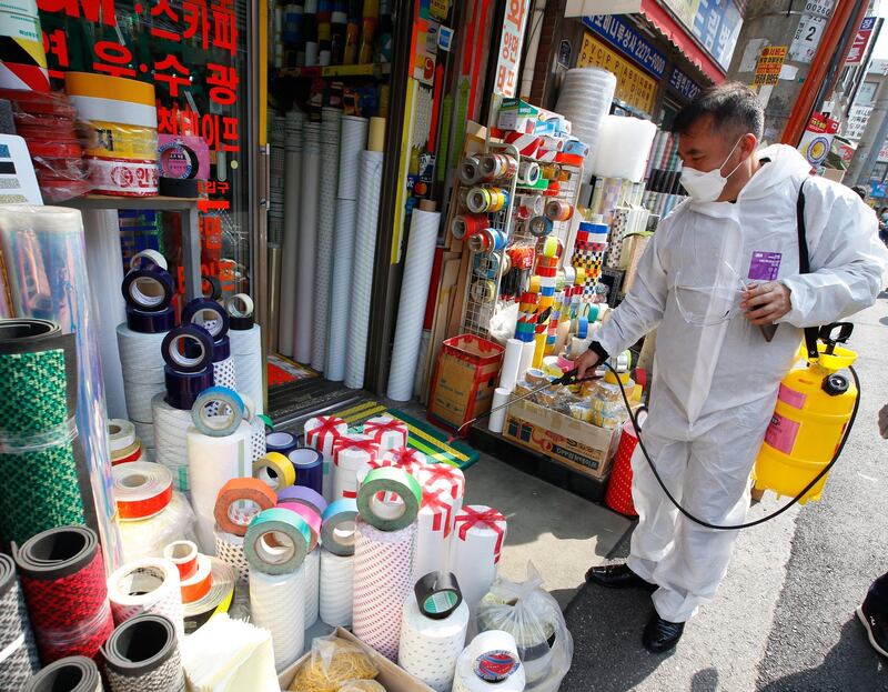 An member of a quarantine team sprays disinfectant as a preventive measure against coronavirus in Bangsan Market in Seoul. EPA