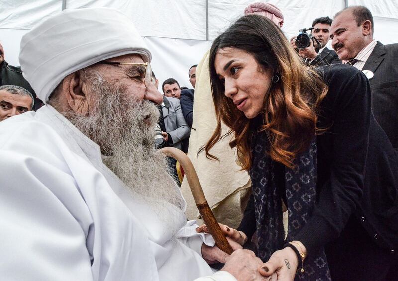 Iraqi Yazidi and Nobel Peace Laureate Nadia Mourad speaks with an elderly Yazidi cleric during the exhumation of a mass-grave of hundreds of Yazidis killed by ISIS militants in the northern Iraqi village of Kojo, Sinjar district. AFP