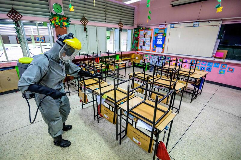A Thai soldier wearing a personal protective equipment (PPE) disinfects a classroom to combat the spread of the Covid-19 coronavirus in Bangkok ahead of the school reopening on February 1.  AFP