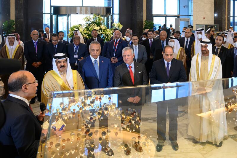 Sheikh Mohamed, King Abdullah, King Hamad, Mr El Sisi and Mr Al Kadhimi look at a model of the Regal Heights Hotel. 

