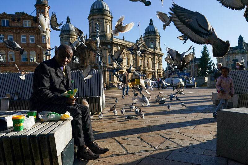 A man reacts as pigeons take flight around him in Hull city centre. Getty Images