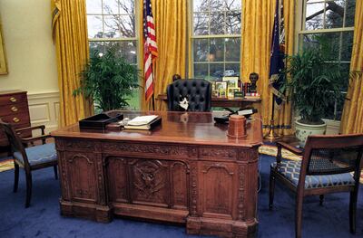 Socks the Cat, the First Pet of President Bill Clinton and First Wife Hillary Rodham Clinton, with black fur, white face, and amber eyes, seated at the tall leather chair behind the President's desk in the Oval Office, looking out into the room, Washington, District of Columbia, January 7, 1994. Courtesy National Archives. (Photo via Smith Collection/Gado/Getty Images).